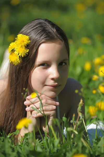 Chica en el prado con flores de diente de león —  Fotos de Stock