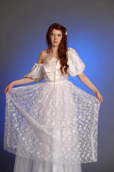 Belle jeune femme en robe blanche. Dans le studio . Photo De Stock