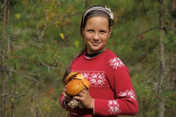 Onnellinen tyttö näyttää sieniä — kuvapankkivalokuva