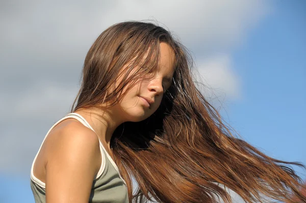 Χαριτωμένο νεαρή κοπέλα με τα μαλλιά που κυματίζουν ελαφρά στον άνεμο — Φωτογραφία Αρχείου