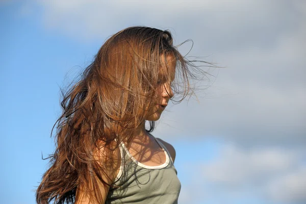 Милая молодая девушка с легкими волосами, развевающимися на ветру. — стоковое фото