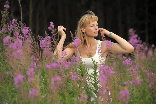 Girl among the flowers in the field — Stock Photo, Image