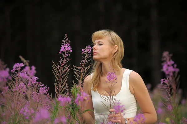 Flicka bland blommor i fältet — Stockfoto