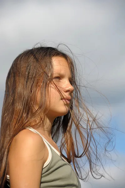 Χαριτωμένο νεαρή κοπέλα με τα μαλλιά που κυματίζουν ελαφρά στον άνεμο — Φωτογραφία Αρχείου