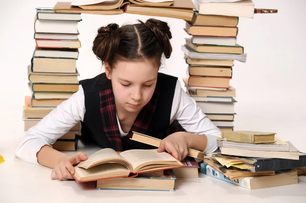 Молодая школьница с большим количеством книг — стоковое фото
