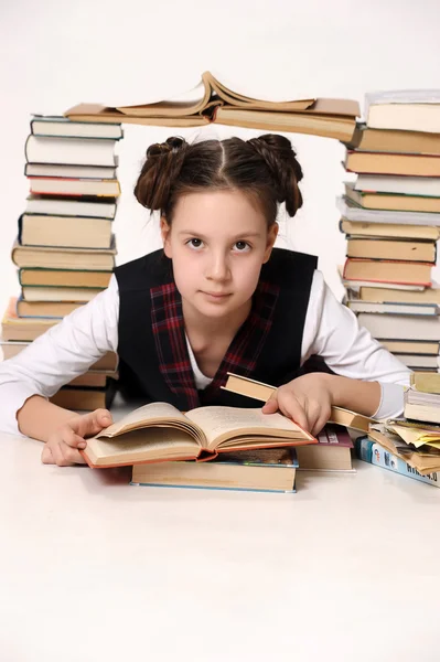 Молодая школьница с большим количеством книг — стоковое фото