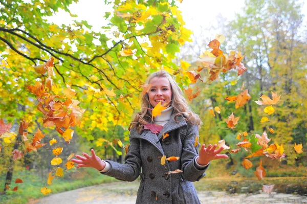 Eğlenceli bir kız fırlatır sonbahar yaprakları — Stok fotoğraf