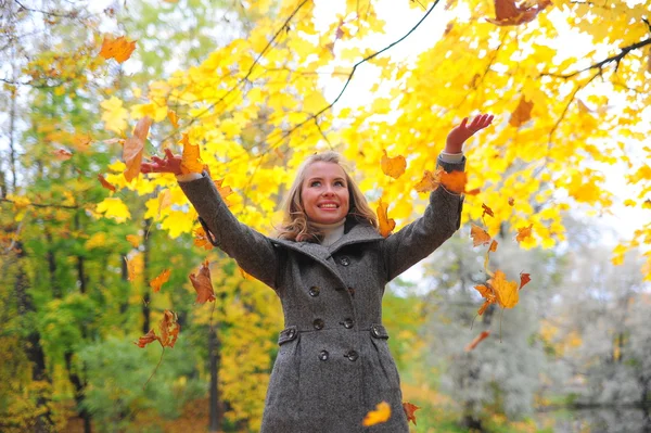Fun girl tosses fall foliage — Stock Photo, Image