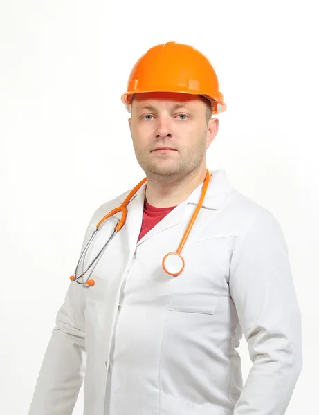 Un hombre con una bata blanca, casco y fonendoscopio . Fotos De Stock