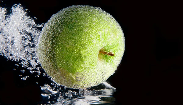 Hela grönt äpple och skiva i vatten — Stockfoto