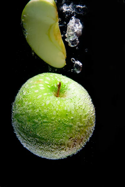 stock image Whole Green Apple and Slice in water