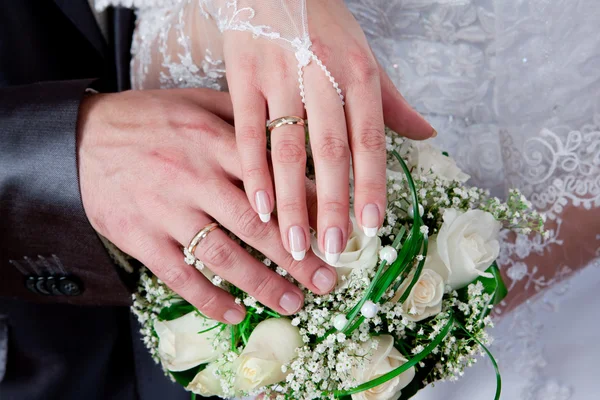 Χέρια και δαχτυλίδια σε γαμήλια ανθοδέσμη Royalty Free Φωτογραφίες Αρχείου