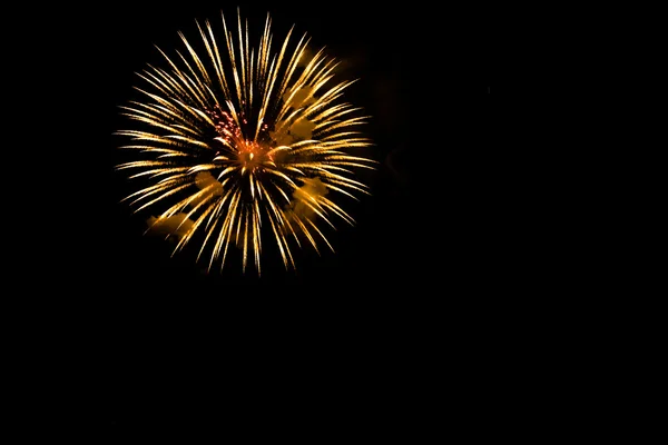 Een uitbarsting van Oranje vuurwerk tegen een nachtelijke hemel. — Stockfoto