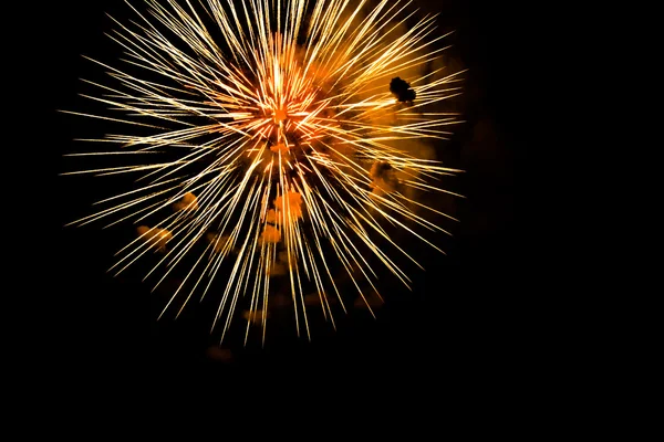 Een uitbarsting van Oranje vuurwerk tegen een nachtelijke hemel. — Stockfoto
