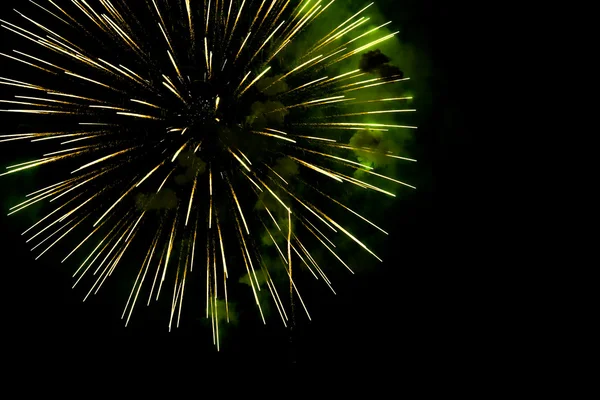 Een uitbarsting van gouden-groene vuurwerk tegen een nachtelijke hemel. — Stockfoto