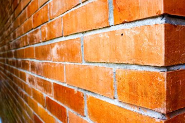 Close-up details voor een oranjebruine bakstenen muurTuruncu-kahverengi tuğla bir duvara yakın çekim detayları.