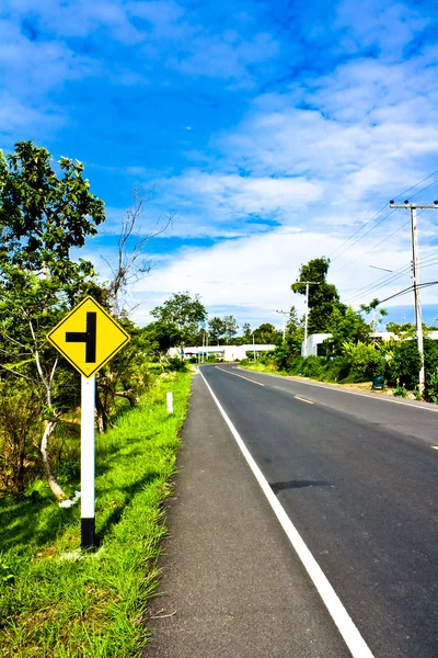 Pustej drodze ze znakiem ruchu w okolicy Tajlandii — Zdjęcie stockowe