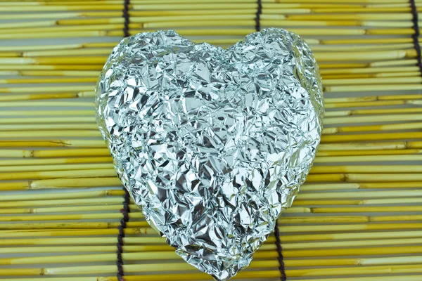 Silbernes Herz auf Bambusrollo — Stockfoto