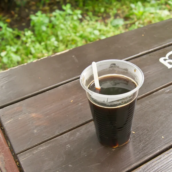 Пластиковая чашка с кофе в летнем кафе . Стоковое Изображение