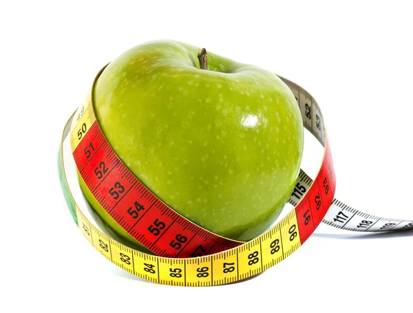 Зеленое яблоко с измерительной лентой на белом фоне — стоковое фото