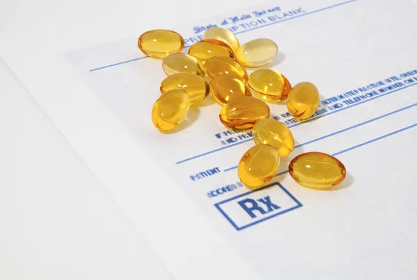 Oil vitamins yellow capsule on the prescription blank — Stock Photo, Image