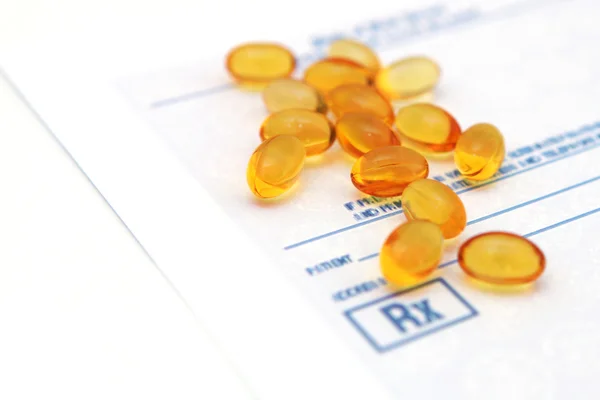 Oil vitamins yellow capsule on the prescription blank — Stock Photo, Image