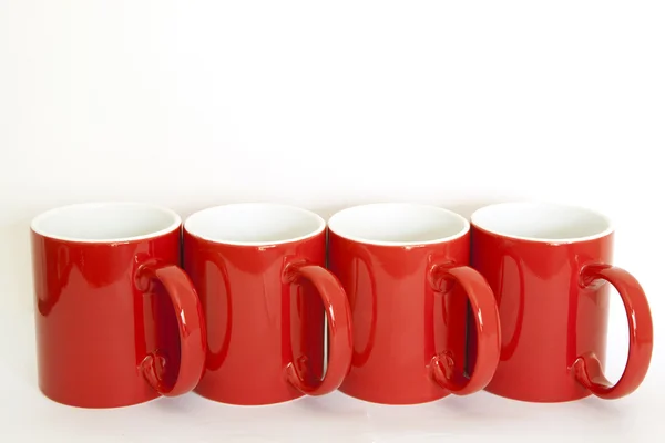 Four red cups on a white background — Stock Photo, Image