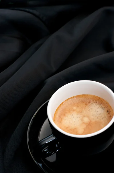 Φλιτζάνι καφέ σε μαύρο υφασματεμποριών — Φωτογραφία Αρχείου