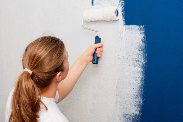 Vrouw die een muur schildert — Stockfoto