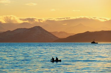 Fishermen boat in sunset clipart