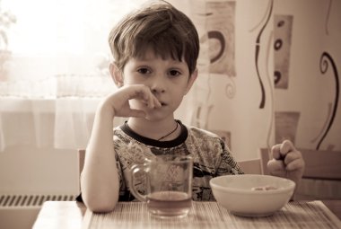 The boy has breakfast clipart