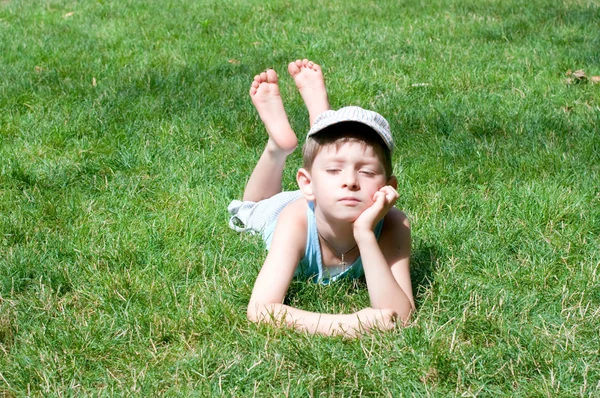 5 歳の少年は、芝生の上を産む — ストック写真