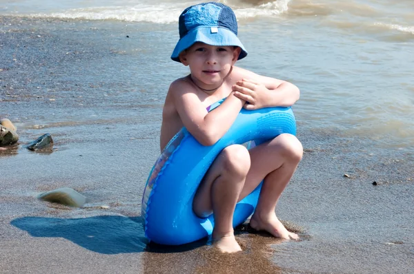 El chico juega a la arena en la costa — Foto de Stock