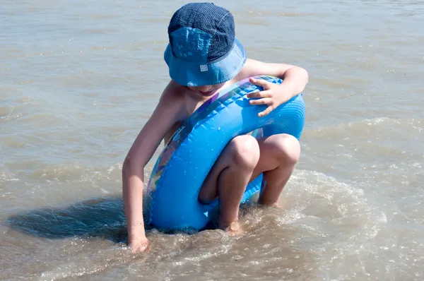 De jongen speelt zand op Zeekust — Stockfoto