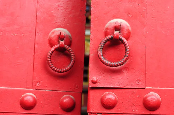 Porta vermelha com maçanetas de ferro — Fotografia de Stock