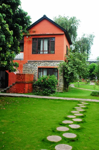 stock image Red house with green meadows