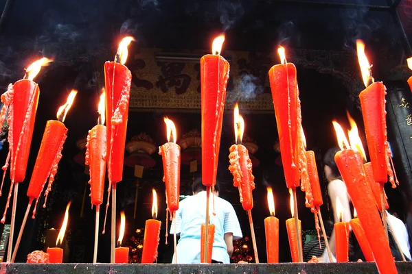 Joss paus e velas queimando em um templo — Fotografia de Stock