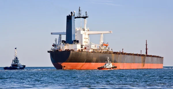 Cargo ship and two tugboats. — Stock Photo, Image
