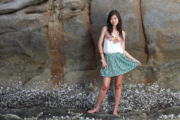 Mooie jonge vrouw die zich voordeed op stenen in de buurt van zee — Stockfoto
