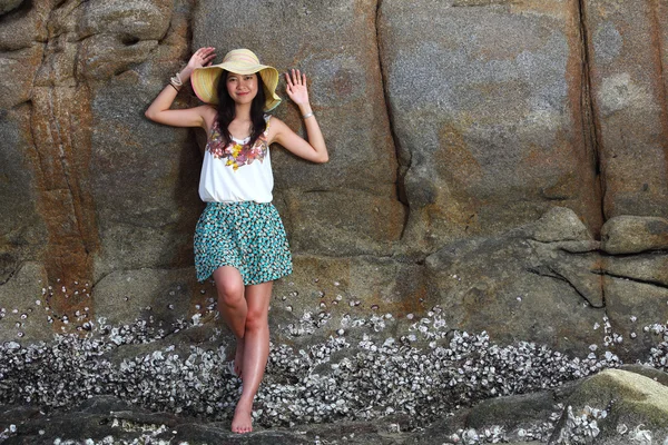 Mooie jonge vrouw die zich voordeed op stenen in de buurt van zee — Stockfoto