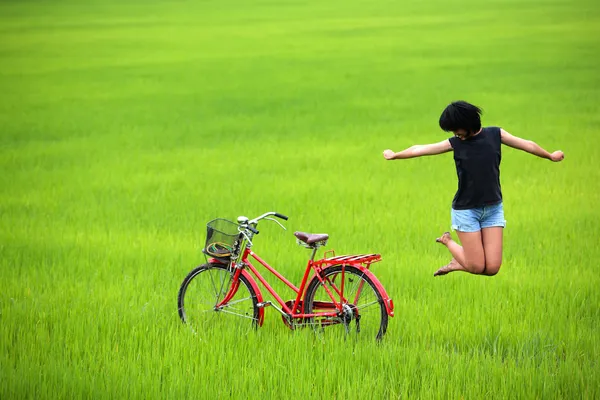 Glad tjej som hoppar i risfält — Stockfoto