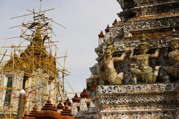 Statue gardienne avec réparation du fond du temple thaï — Photo