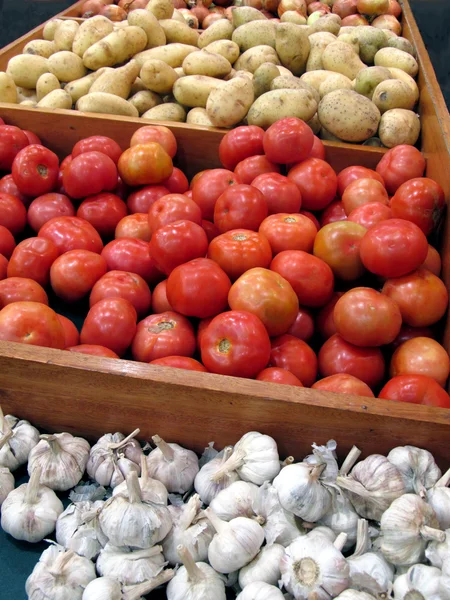 Knoflook aardappelen en tomaten in vegateble stand — Stockfoto