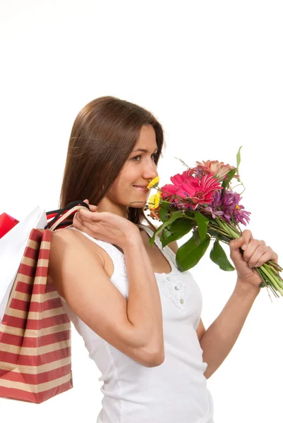 Mulher segurando sacos de compras, presentes e buquê de flores — Fotografia de Stock