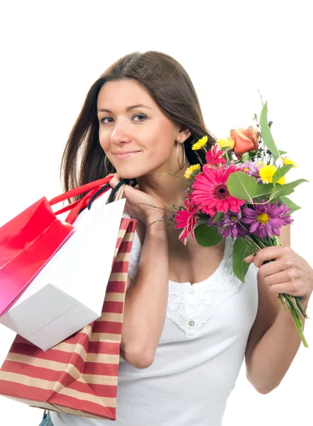 Kobieta trzyma torby na zakupy, prezenty i bukiet kwiatów — Zdjęcie stockowe