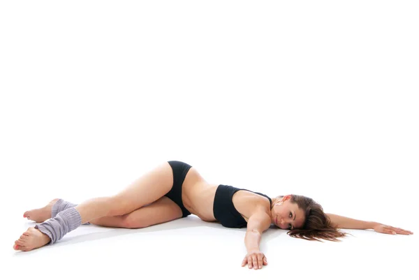 美丽的女人躺在地上做瑜伽姿势 — 图库照片