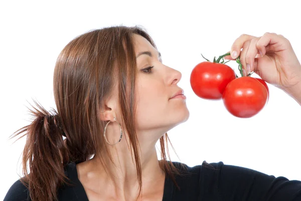 Młoda kobieta zapach czerwone pomidory — Zdjęcie stockowe