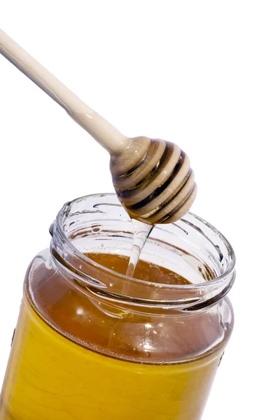 Bottle of honey and wooden spoon. — Stock Photo, Image