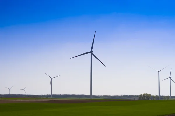 stock image Wind power plants in the field, blue sky in the background.