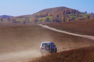 Off-road vehicle running in the grassland clipart